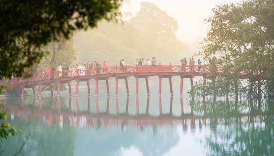 Bridge with people in fog. Hanoi, Vietnam.